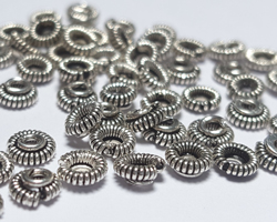  sterling silver 4.1mm x 1.8mm coiled wire spacer, 1.4mm hole, numerous imperfections which are part of the charm of these lovely spacers 